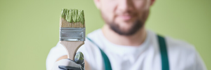 Man holding green paint brush