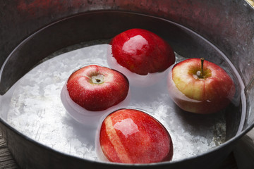 Metal basin with apples in water. Autumn harvest background