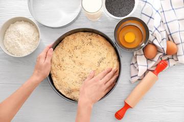 Woman preparing cake on kitchen table