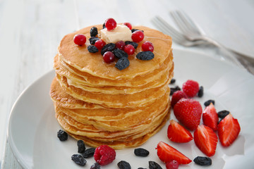 Plate with delicious pancakes on table