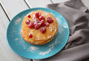 Plate with delicious pancakes on table