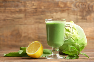 Composition with fresh green smoothie on wooden background