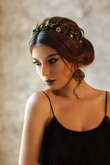 Fototapeta premium Fashion portrait of a beautiful young woman with a black jewelry