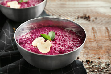 Bowl with delicious creamy beet hummus on table