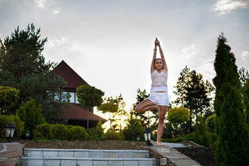 Woman Yoga - relax in nature. woman practices yoga and meditates