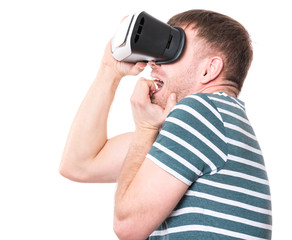 Young man with a frightened pose with virtual reality goggles watching movies or playing video games, isolated on white background. Man is looking scared. People experiencing 3D gadget technology.