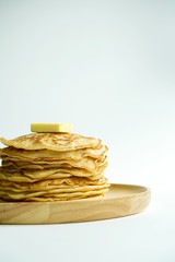 close up pancakes and butter in wood plate with white background
