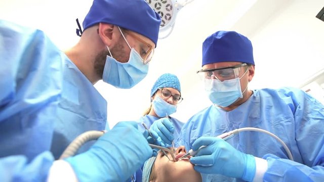 Dentist doctor and his team treating a patient at clinic