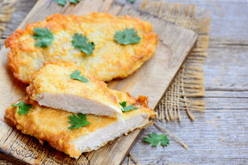 Fried chicken breast on a cutting board. Quick and easy chicken recipe for dinner. Vintage wooden background