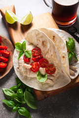 Home tortilla with hummus of white beans and beer on a gray stone table. Italian, Mediterranean style. With tomatoes and basil . dark beer