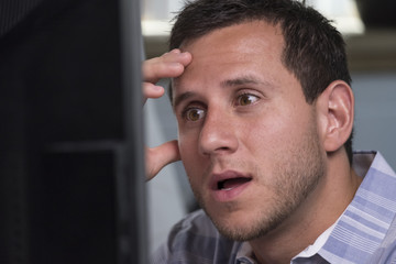 Obraz premium Man looking overwhelmed while looking at his computer
