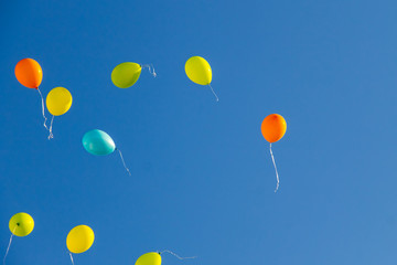 Colorful balloons flying in blue sky
