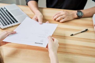 Young woman submit resume to employer to review job application. The concept presents the ability for the company to agree with the position of the job.