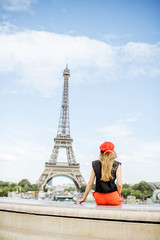 Fototapeta na wymiar Woman in red enjoying great view on the Eiffel tower in Paris