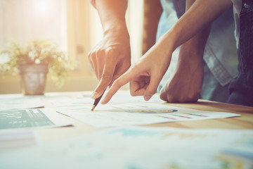 Hand pointing to a financial document on the desk. Between the agreed form of work to send...