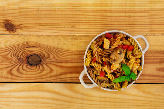 Pasta with vegetable sauce on wooden background