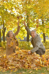 couple throwing leaves up