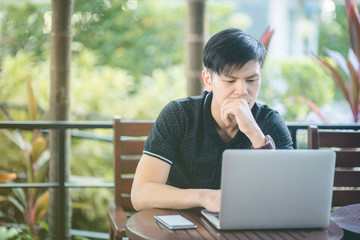 Businessman working laptop for new architectural project, sitting at table in cafe and uses laptop.Nearby is smartphone. Generic design notebook on the table. Freelancer working outside office