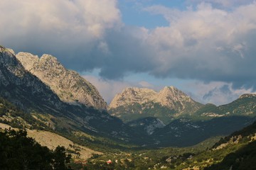 Naklejka premium Clouds above the north Albanian mountains, at sunset time. Seen from the village Boge next to Theth National Park in Albania. Southeast Europe.