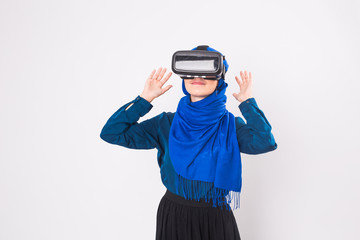 Asian muslim woman wearing hijab using VR headset glasses of virtual reality on white background.