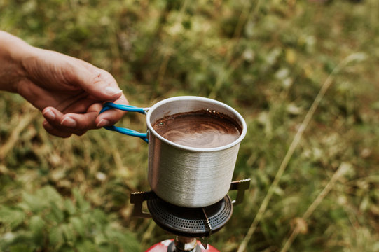 Woman making coffee on portable camping stove