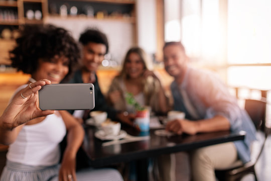 Group of friends at cafe taking selfie