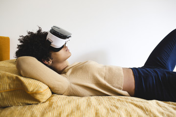 Teen girl with 3d glasses lying on bed