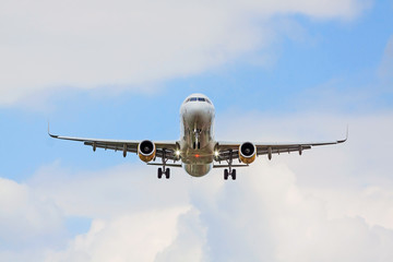 airplane flying overhead - landing / takeoff - blue sky with clouds