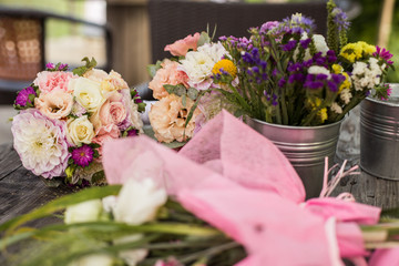 Wedding bouquet with pink, white and violet flowers - set on a wooden table. 