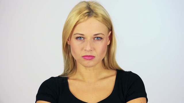 A young attractive woman shakes her head angrily at the camera - face closeup - white screen studio
