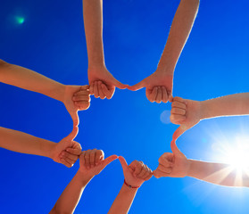 Много дети руки на фоне голубого неба с облаками