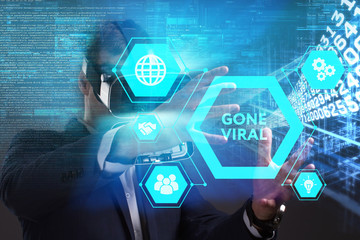 Business, Technology, Internet and network concept. Young businessman working in virtual reality glasses sees the inscription: Gone viral
