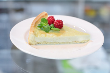 Classic New York cheesecake with raspberry and mint on a white plate