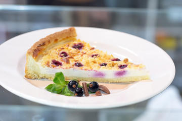 Cheesecake with black currant on a white plate