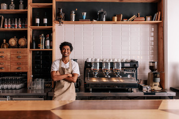 Barista in apron looking at camera and smiling