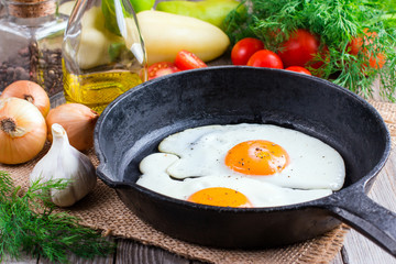 Fried eggs in a frying pan on a black background