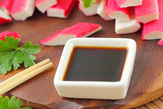 Soy sauce in a square bowl and crab sticks