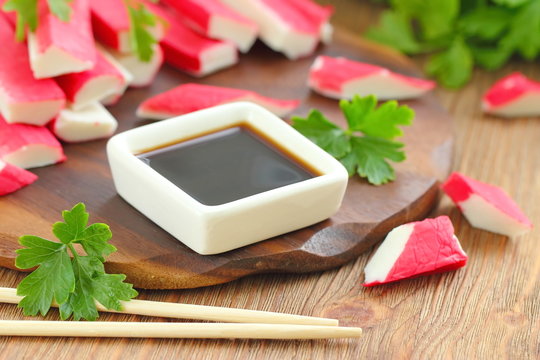 Soy sauce in a square bowl and crab sticks