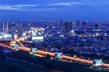 Obraz premium city skyline with highway and railway at sunset, long exposure photography for traffic movement