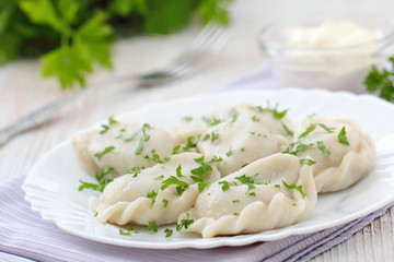 Dumplings with sour cream and fresh parsley