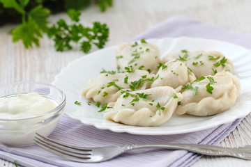 Dumplings with sour cream and fresh parsley