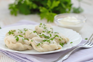 Dumplings with sour cream and fresh parsley