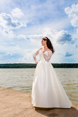 Fototapeta na wymiar Portrait of very beautiful bride and cloudy sky