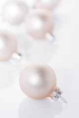 White Christmas balls scattered on light background. High key image. Template for greeting card, poster, banner, invitation. Clean minimalist scandinavian style.