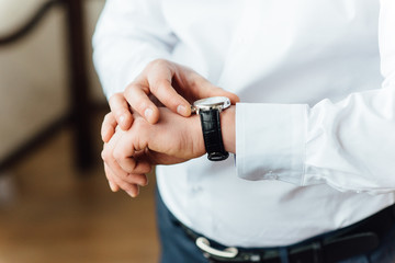 Obraz na płótnie Canvas Fat groom clasping stylish watch band on his wrist