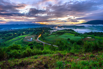 Dramatic vivid sunrise, sea of fog with romantic cloudy sky, mountain background. Beauty of dawn sunbeam valley scene at Khao Takhian Ngo, Petchabun, Thailand.