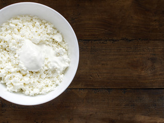 A plate of grainy cottage cheese on a wooden table
