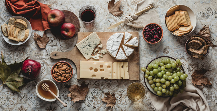 Table with cheese, fruits, crackers and wine