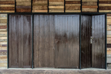 Locked wooden folding doors at bungalow in countryside. Folding doors pattern.