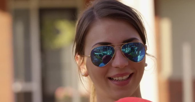 Young woman smiling with sunglasses on - slow motion
